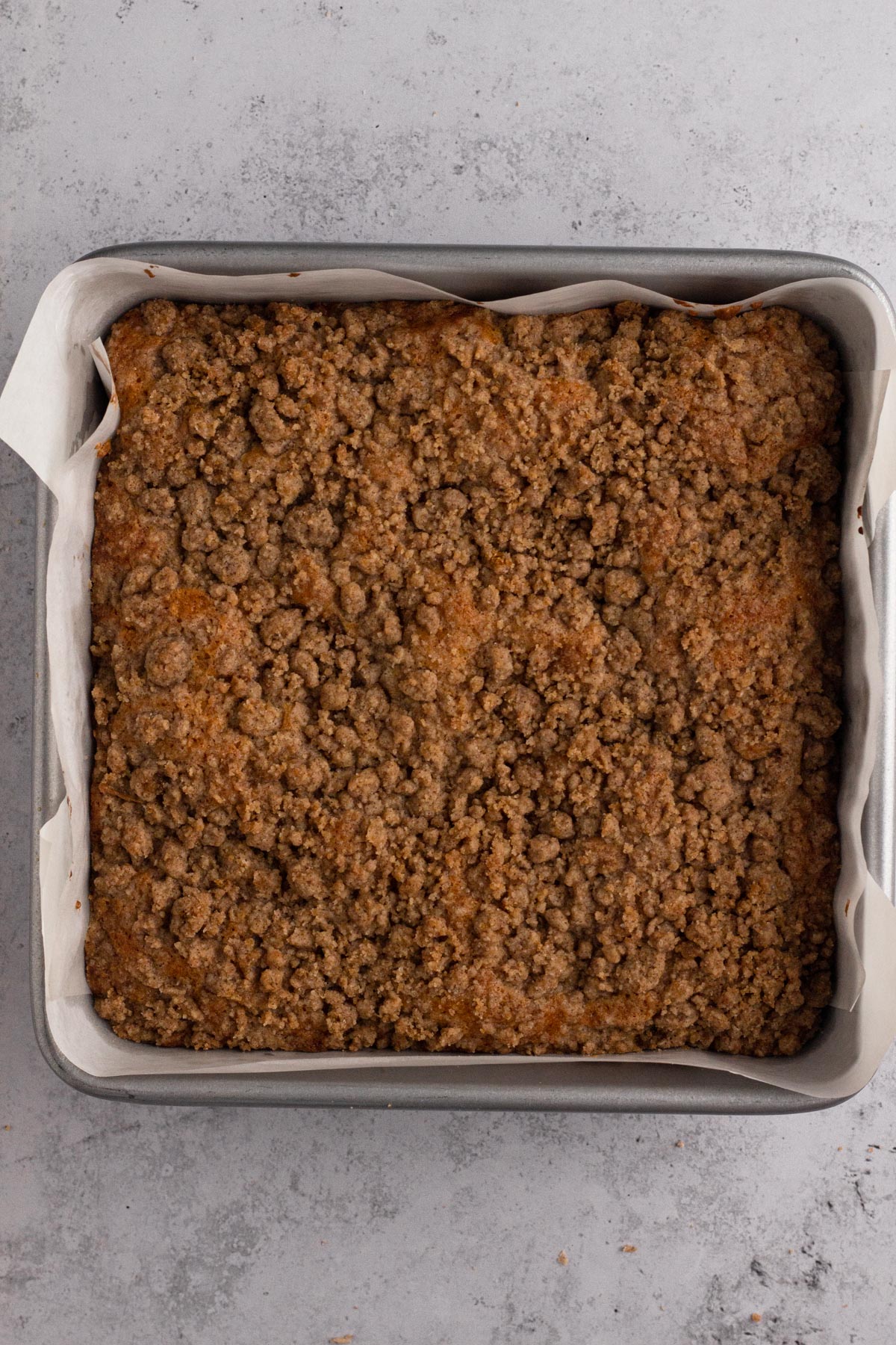 Baked crumb-topped coffee cake in a square baking pan.