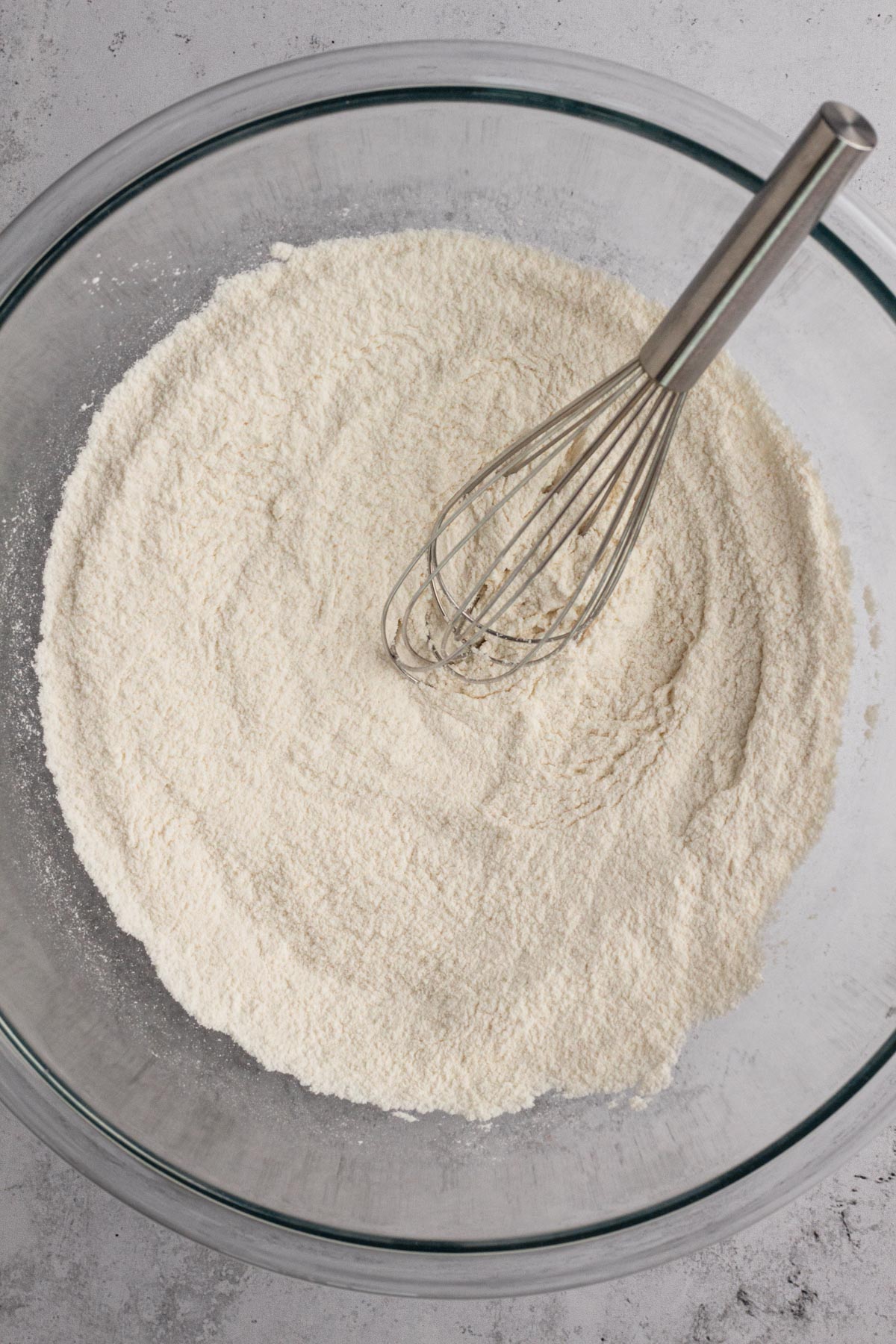 Dry ingredients whisked together in a glass bowl.