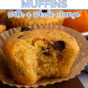 A bitten muffin on a wooden cutting board with a whole orange and a text overlay.