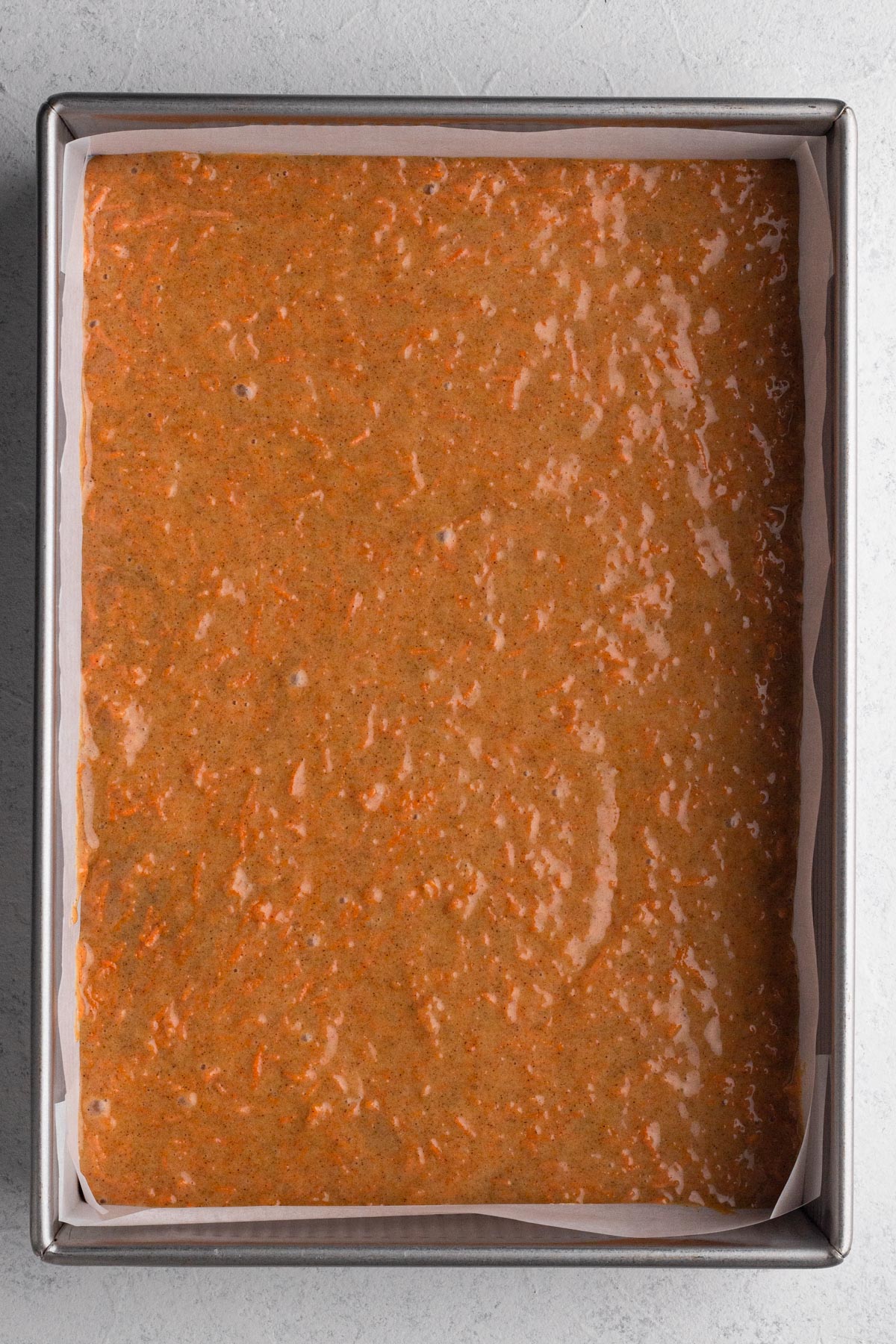 Cake batter in a 9x13 metal baking pan.