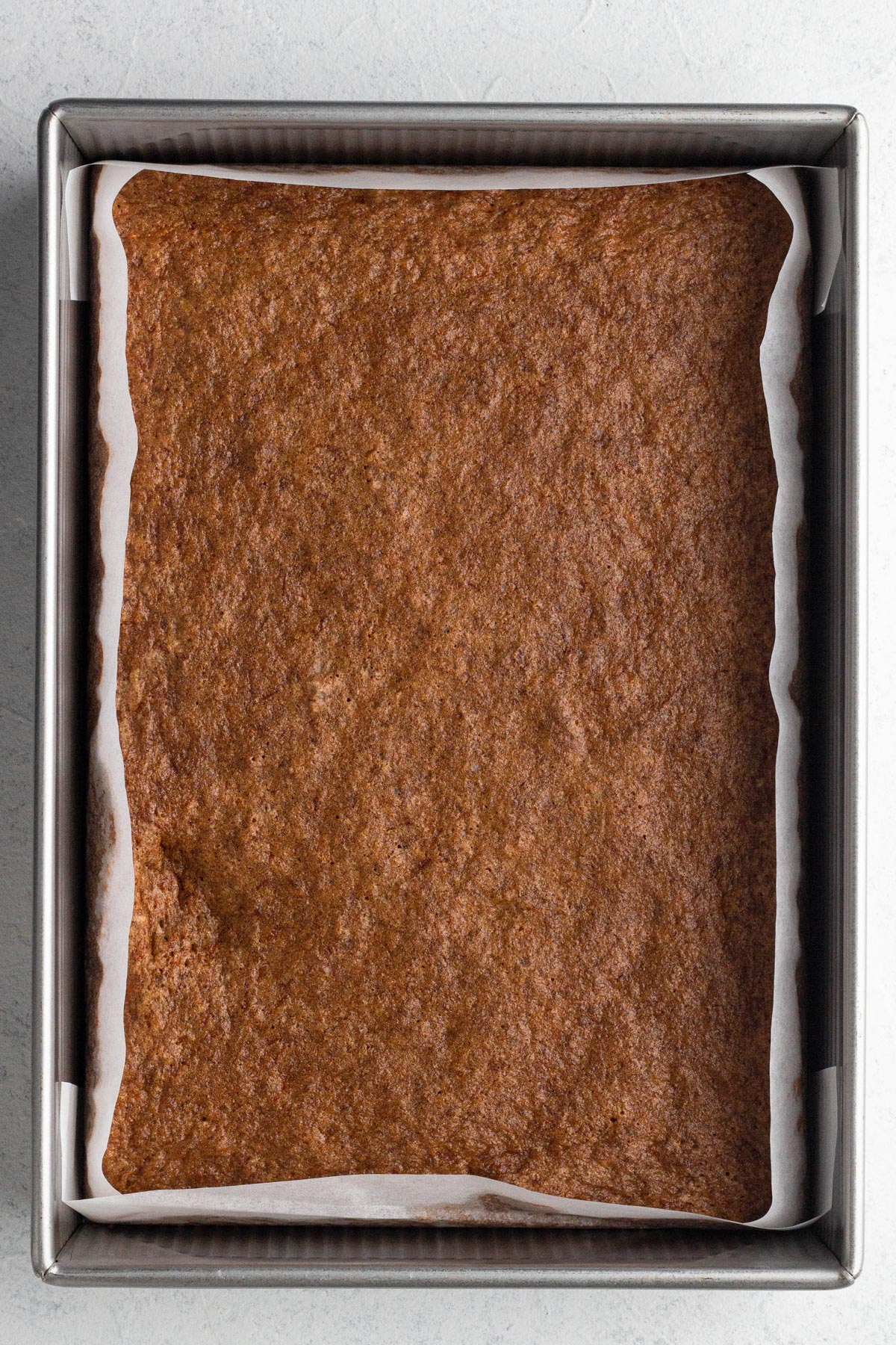 Baked cake in a 9x13 metal baking pan.