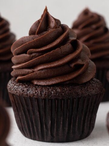 A chocolate cupcake topped with a swirl of chocolate frosting.