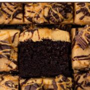 Square slices of chocolate cake topped with peanut butter frosting, peanut butter cups, and drizzles of chocolate and peanut butter with a text overlay.