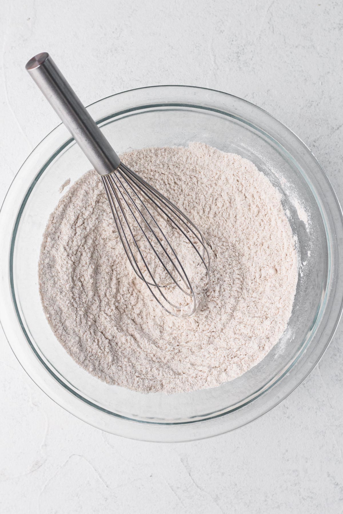 Dry ingredients whisked together in a glass mixing bowl.