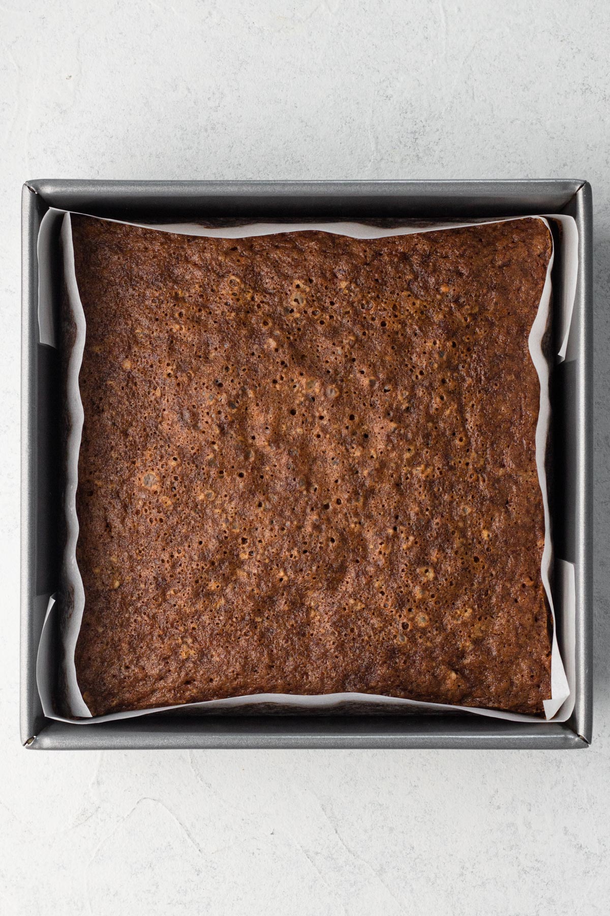 Baked cake in a square metal pan.