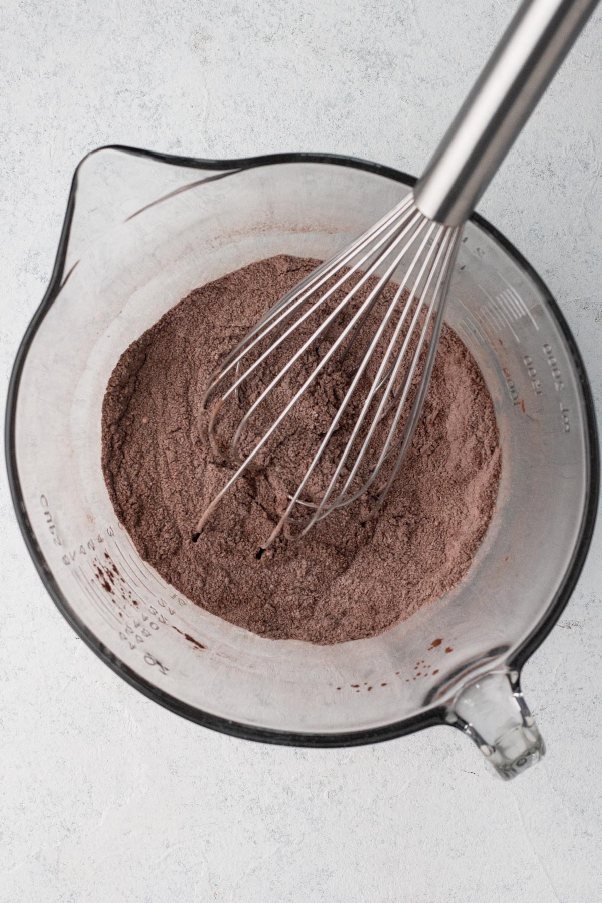 Dry ingredients whisked together in a glass batter bowl.