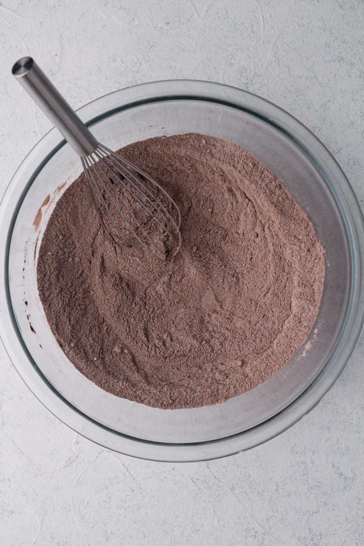 Dry ingredients whisked together in a glass mixing bowl.