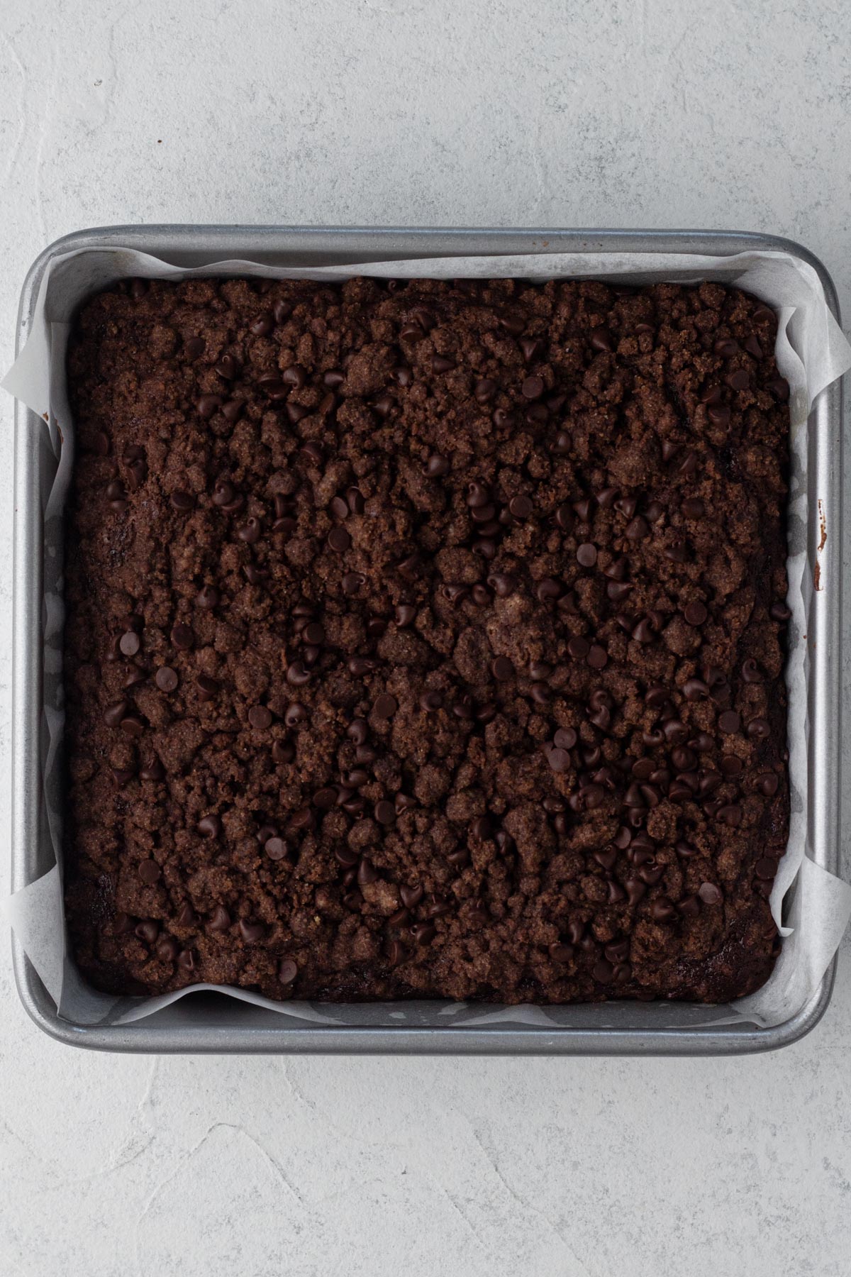 Baked chocolate crumb cake in a square metal baking pan.