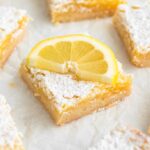 Angled view of a lemon bar with a lemon slice.