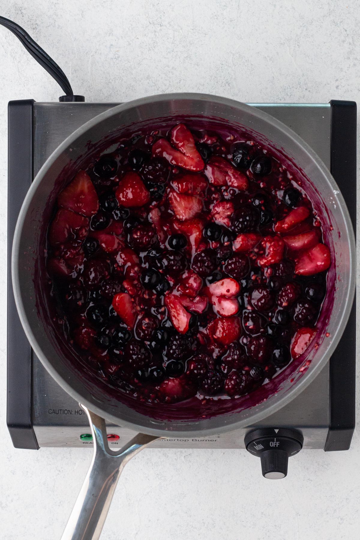 Fruit filling cooking in a sauté pan.