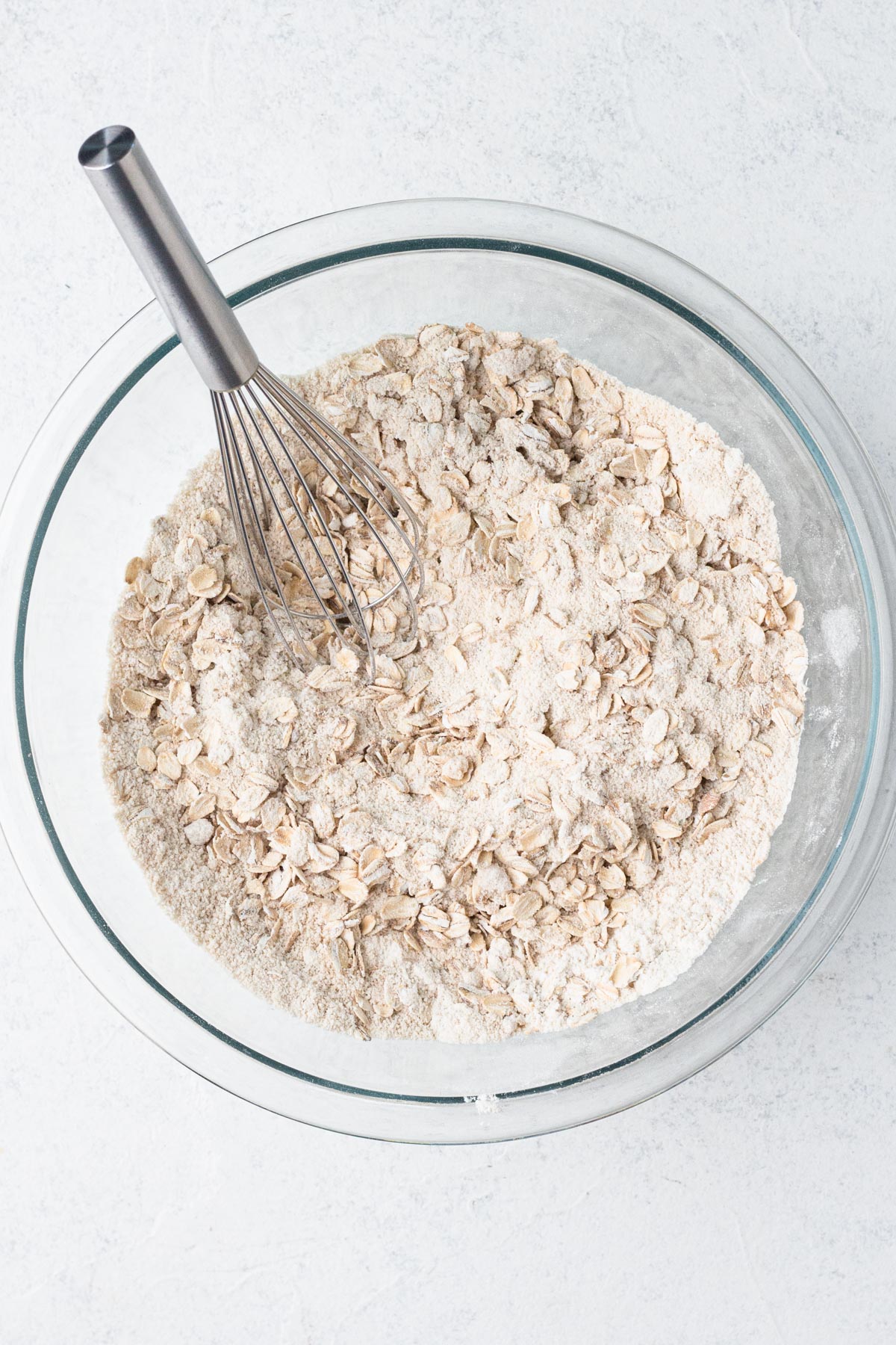 Crumble dry ingredients whisked together in a glass mixing bowl.