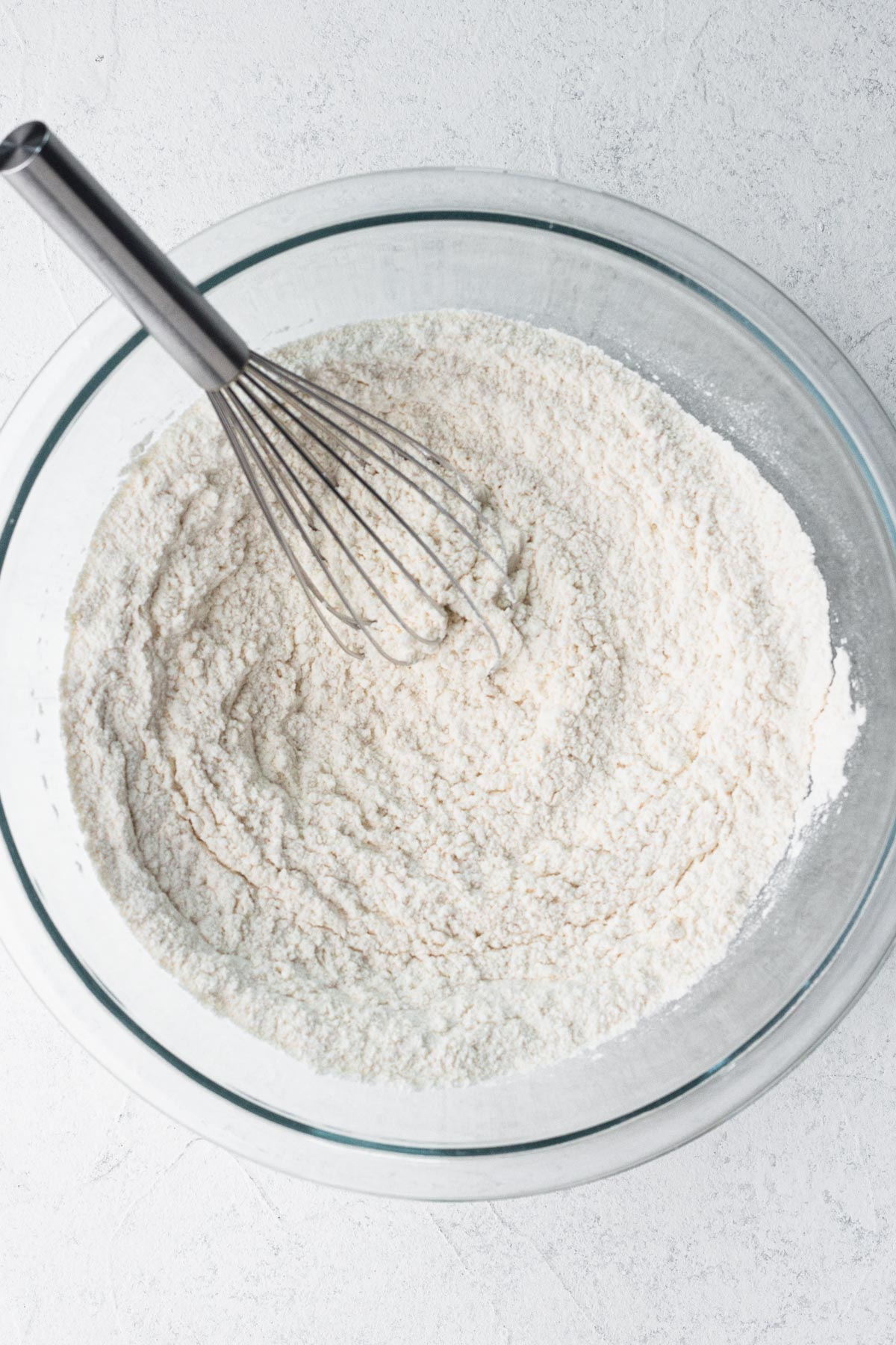 Dry ingredients whisked together in a glass mixing bowl.