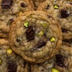 Stacked cookies with bits of chocolate and chopped pistachios.