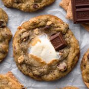 S'mores cookies with toasted marshmallow, graham cracker crumbs, and milk chocolate bar with a text overlay.