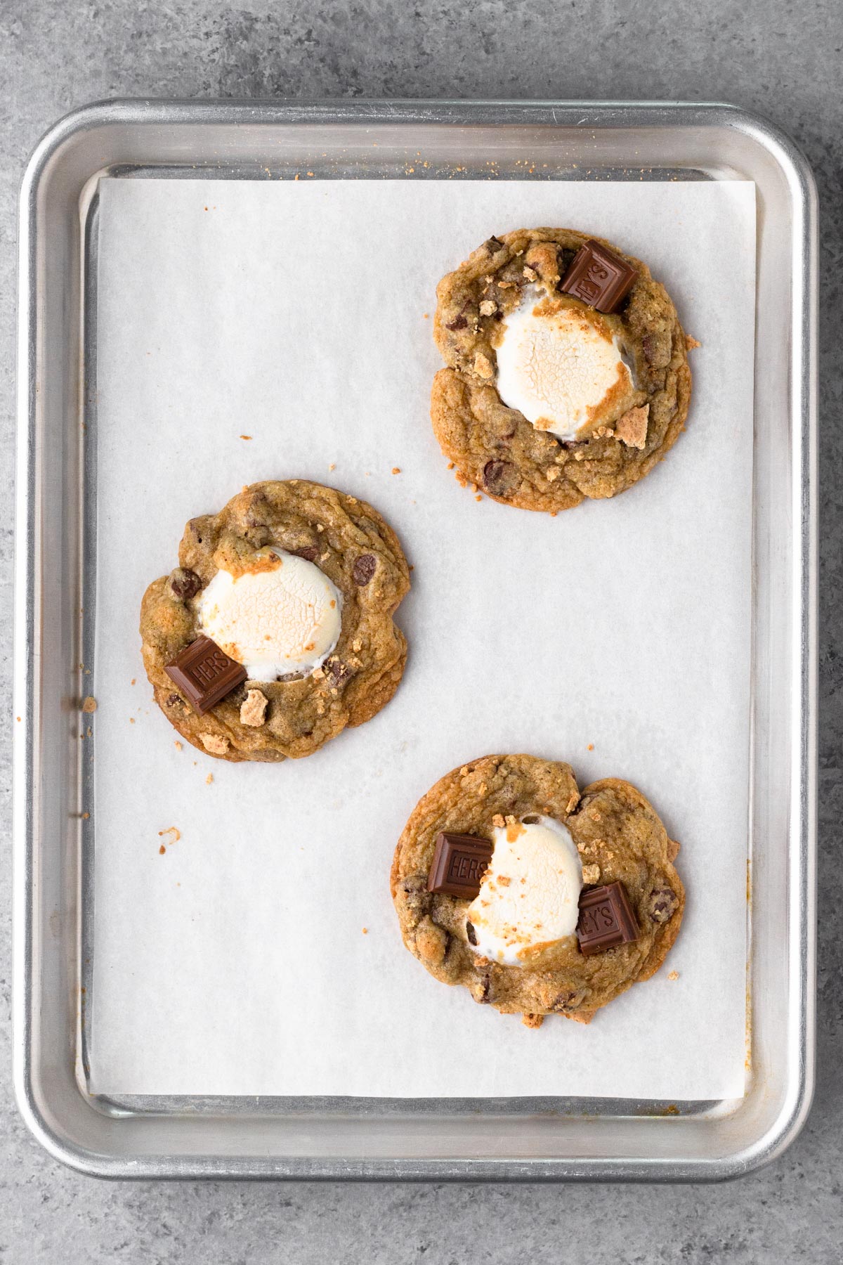 Baked cookies with marshmallow centers on a baking sheet.