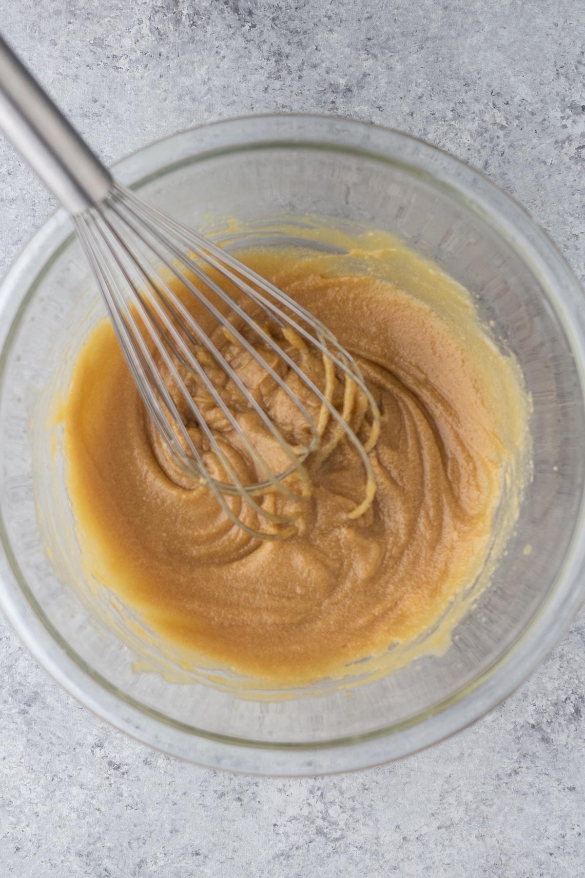 Wet ingredients whisked together in a glass mixing bowl.