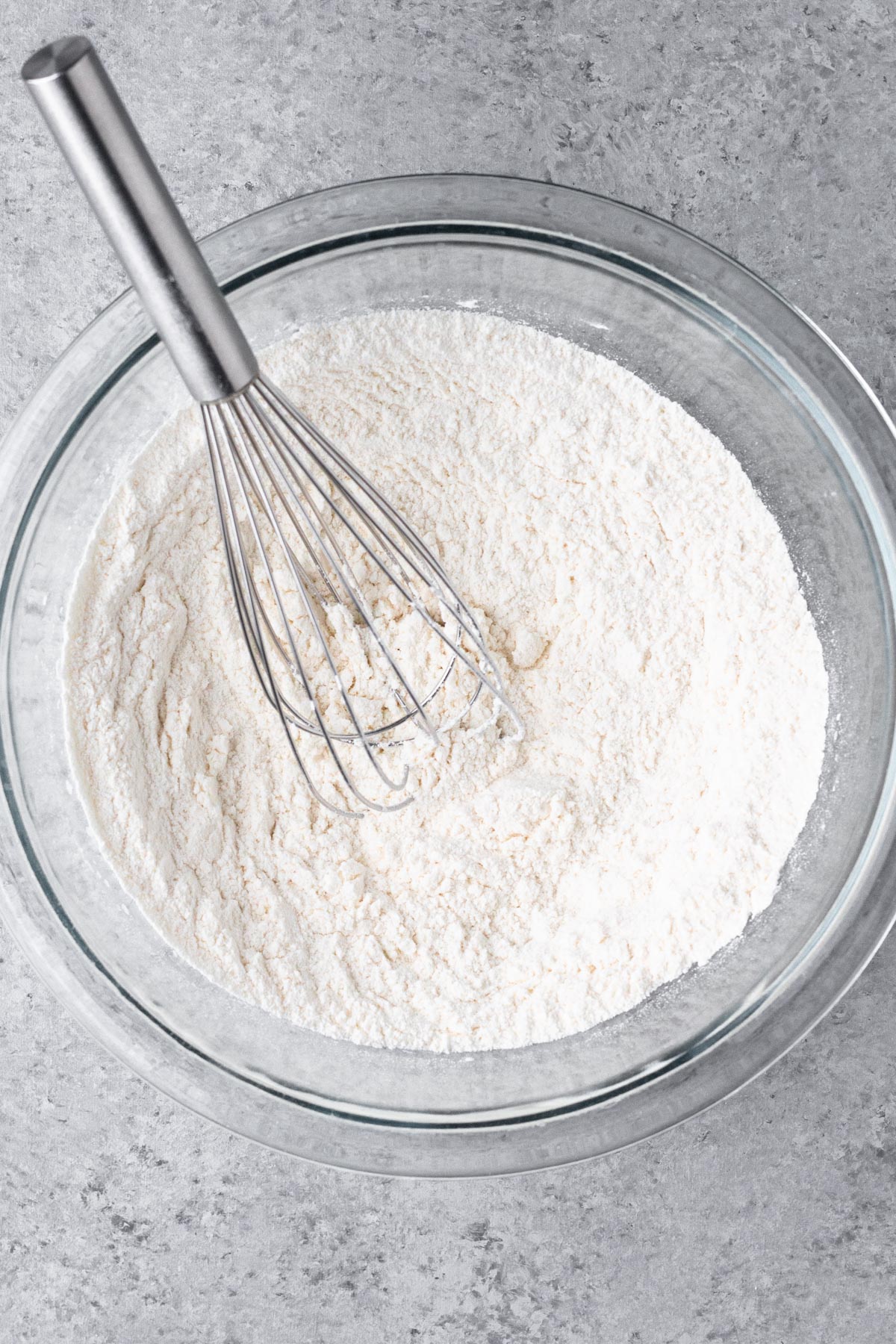 Dry ingredients whisked together in a glass mixing bowl.