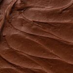 Close-up view of chocolate frosting spread on top of a cake.