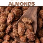 Candied almonds coated in cinnamon sugar on a wooden spoon with a text overlay.
