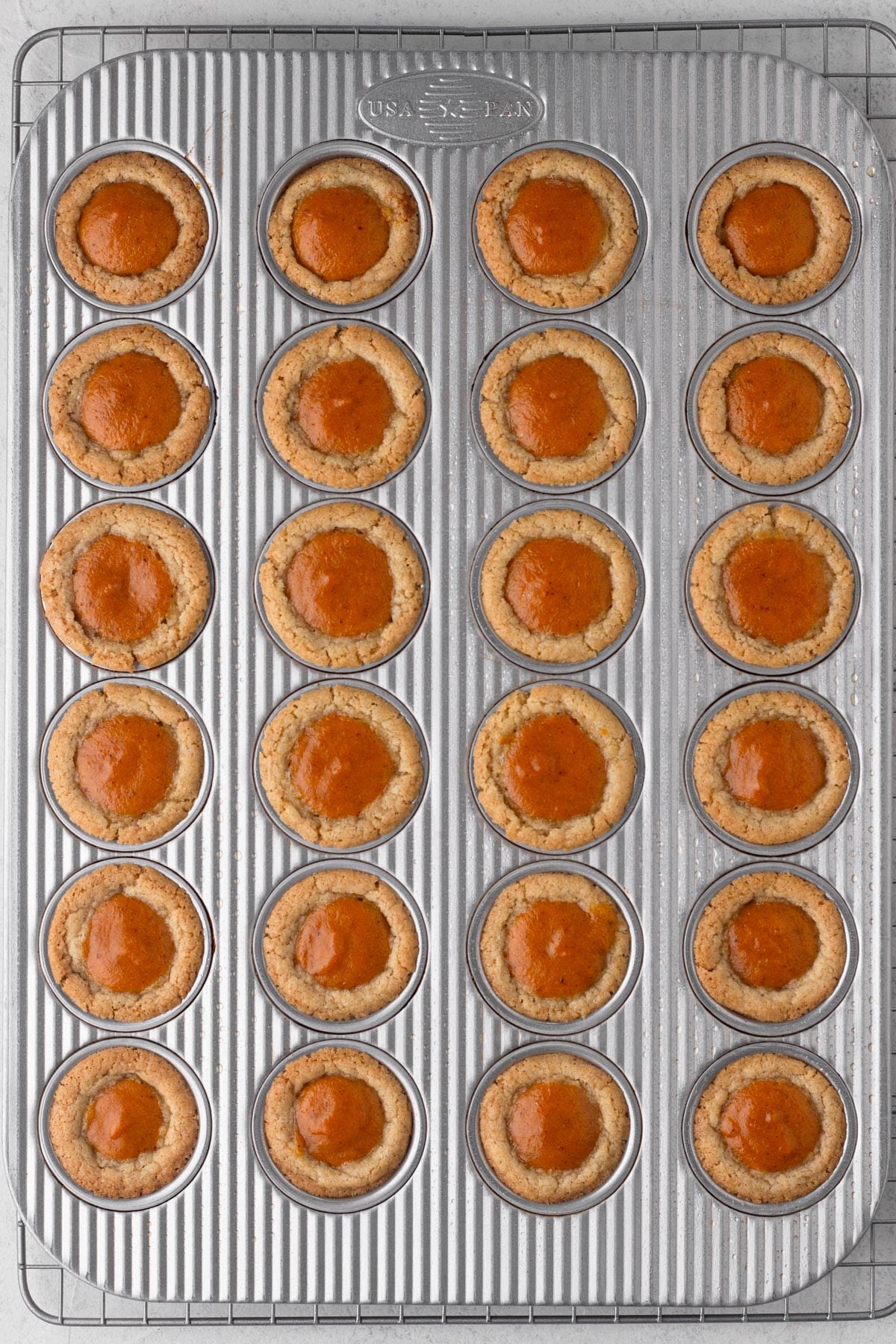 Baked pumpkin pie cookie cups in a mini muffin pan.