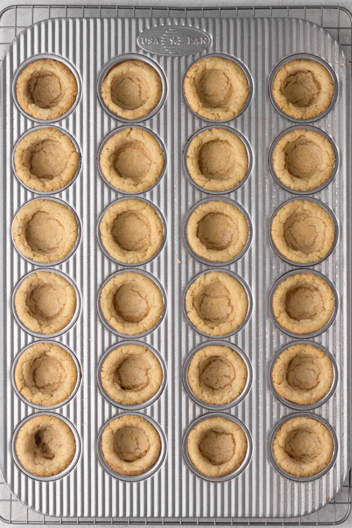 Baked sugar cookie cups in a mini muffin pan.