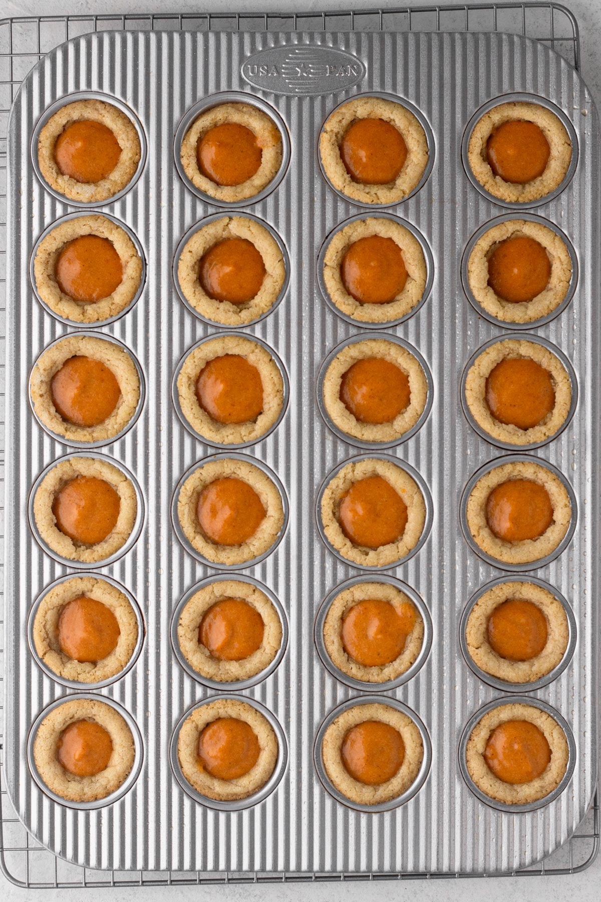 Pumpkin pie filling in baked sugar cookie cups.