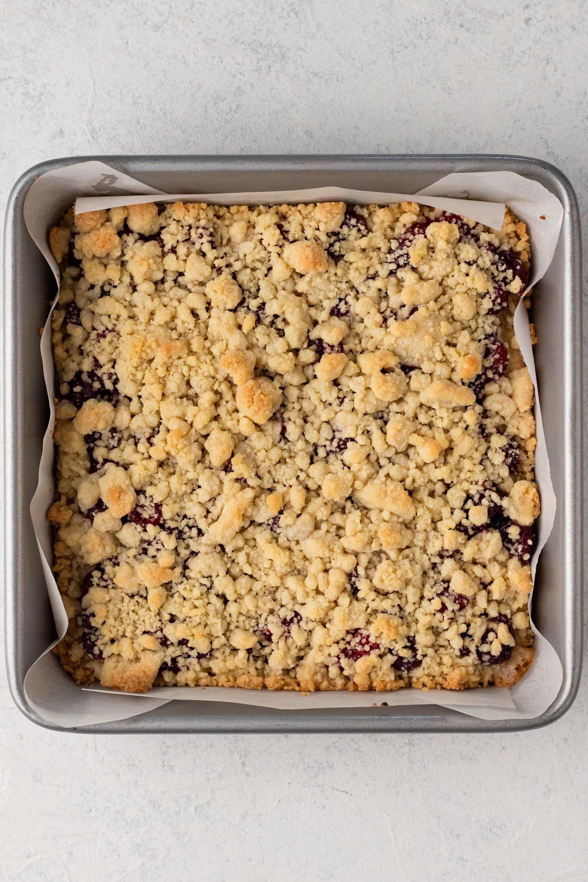 Baked cranberry bars in a square metal pan.