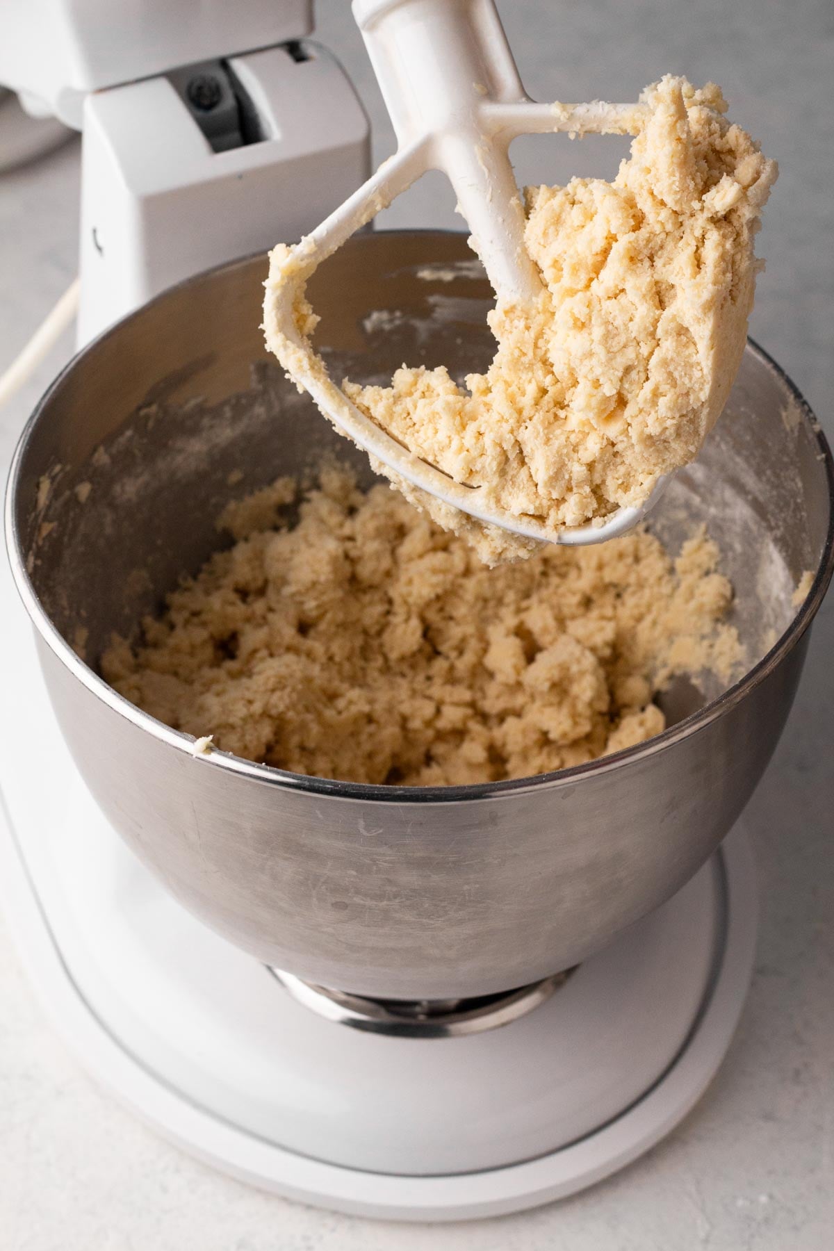 Shortbread cookie dough in the bowl of a stand mixer.