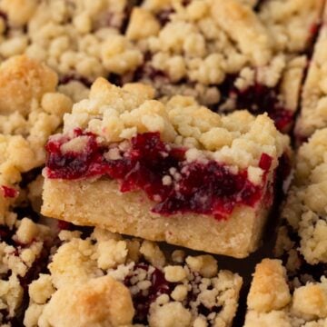 Close-up angled view of a cranberry shortbread bar with crumble topping.