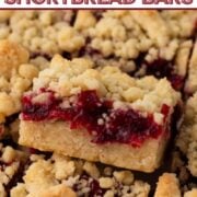 Angled view of a shortbread bar with cranberry filling and crumble topping with a text overlay.